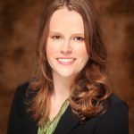 Eliza Van Orman, a professional woman wearing a green shirt and business suit.