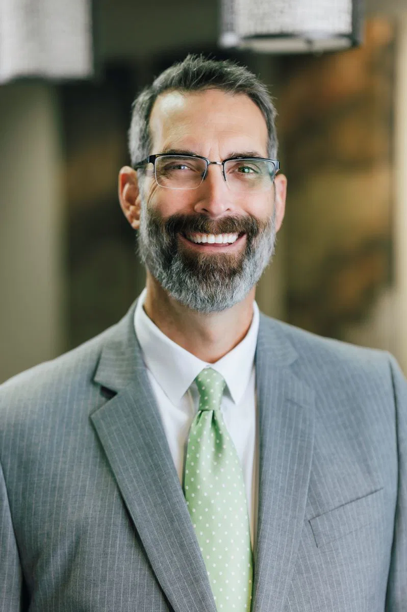 Darin Vandehei, a man with a beard and glasses, dressed in a gray suit