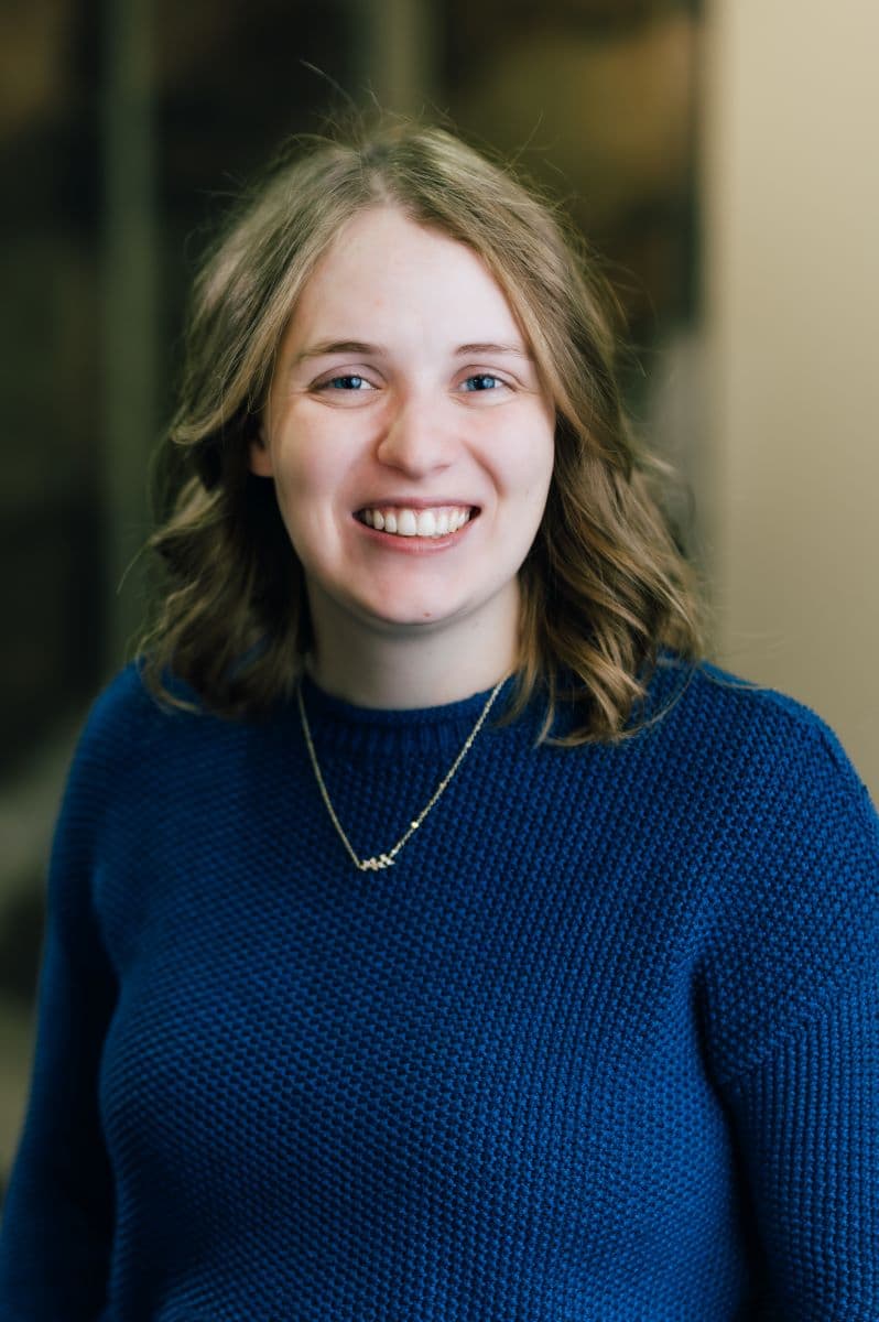 A smiling woman named Kate Tovar wearing a blue sweater.
