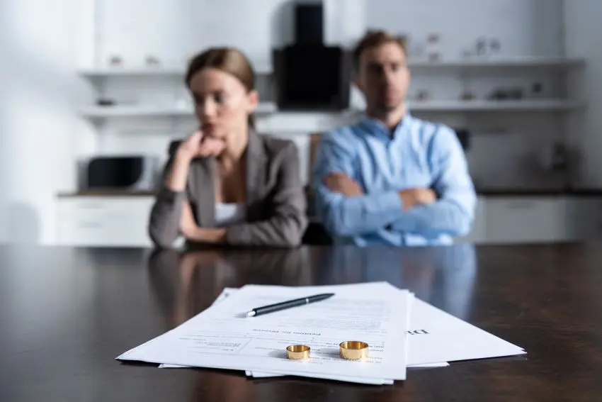 A couple in a divorce meeting with Burton Family Attorneys, navigating the complexities of their separation in a formal environment.