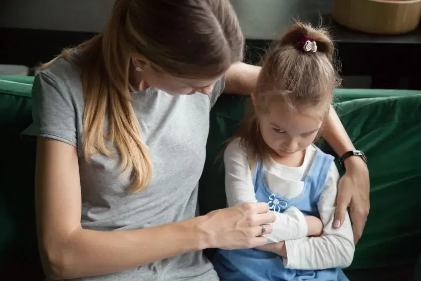 A woman and a young girl seated together on a couch, representing warmth and family connection at Burton Family Attorneys.