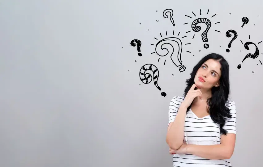 A woman ponders, with question marks floating above her head, symbolizing contemplation and inquiry at Burton Family Attorneys.