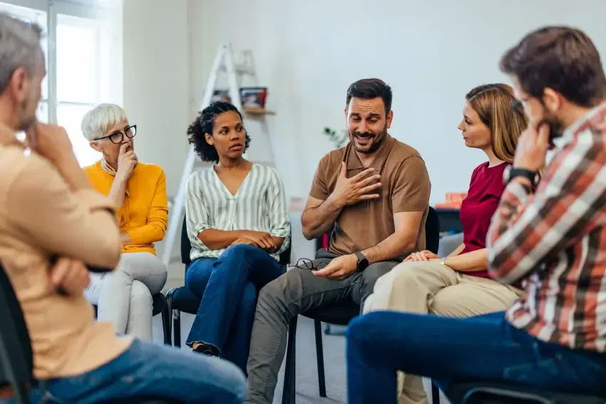 A group of individuals engaged in discussion while seated in a circle, representing collaboration at Burton Family Attorneys.