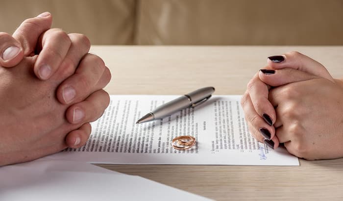 A couple signing divorce papers with family attorneys at law for divorce consultation
