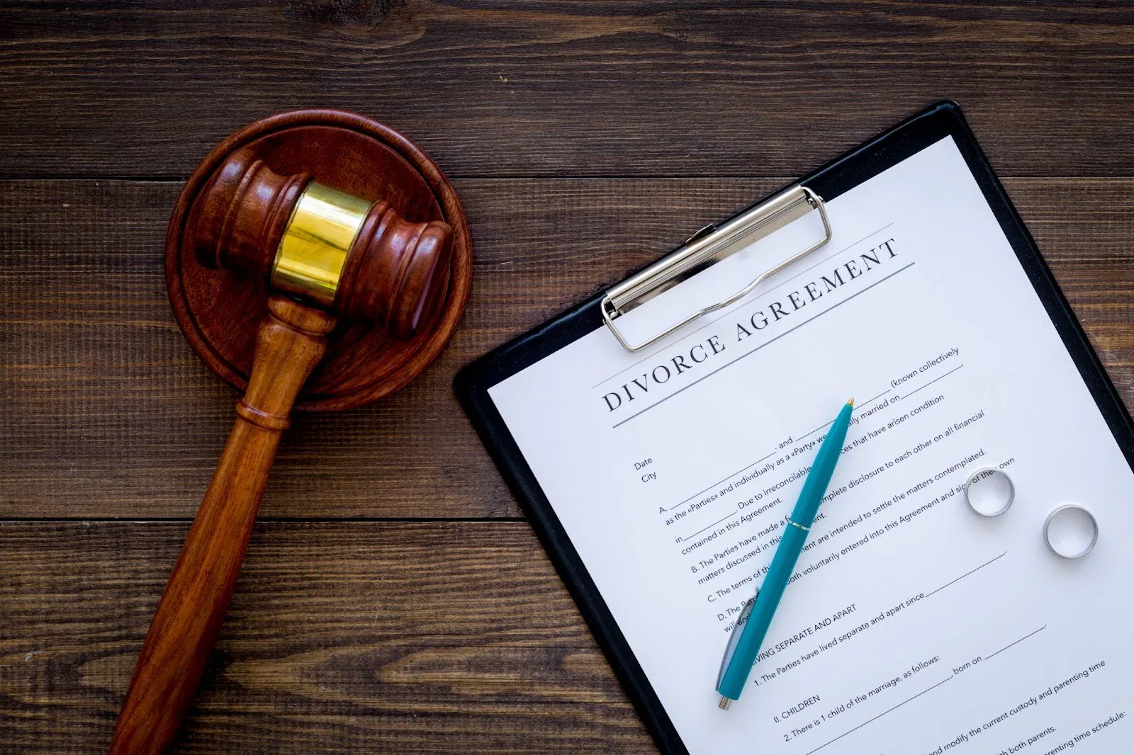 A judge's gavel and marriage contract on a polished table symbolize legal union.