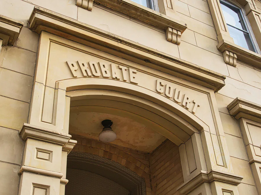 Exterior view of a probate court building entrance, showcasing an ornate archway with 'Probate Court' engraved in bold letters above. Legal services related to wills and estates.