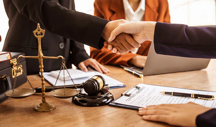 Two business professionals shaking hands over a desk, symbolizing agreement on legal custody matters in Utah.