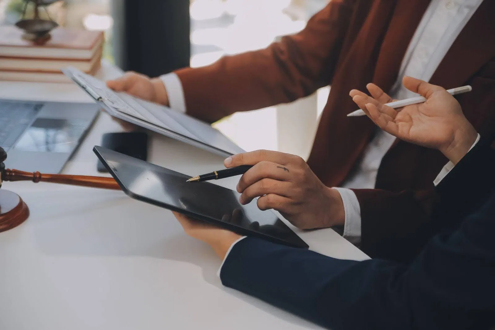 A lawyer and client discuss legal matters in an office filled with documents and books