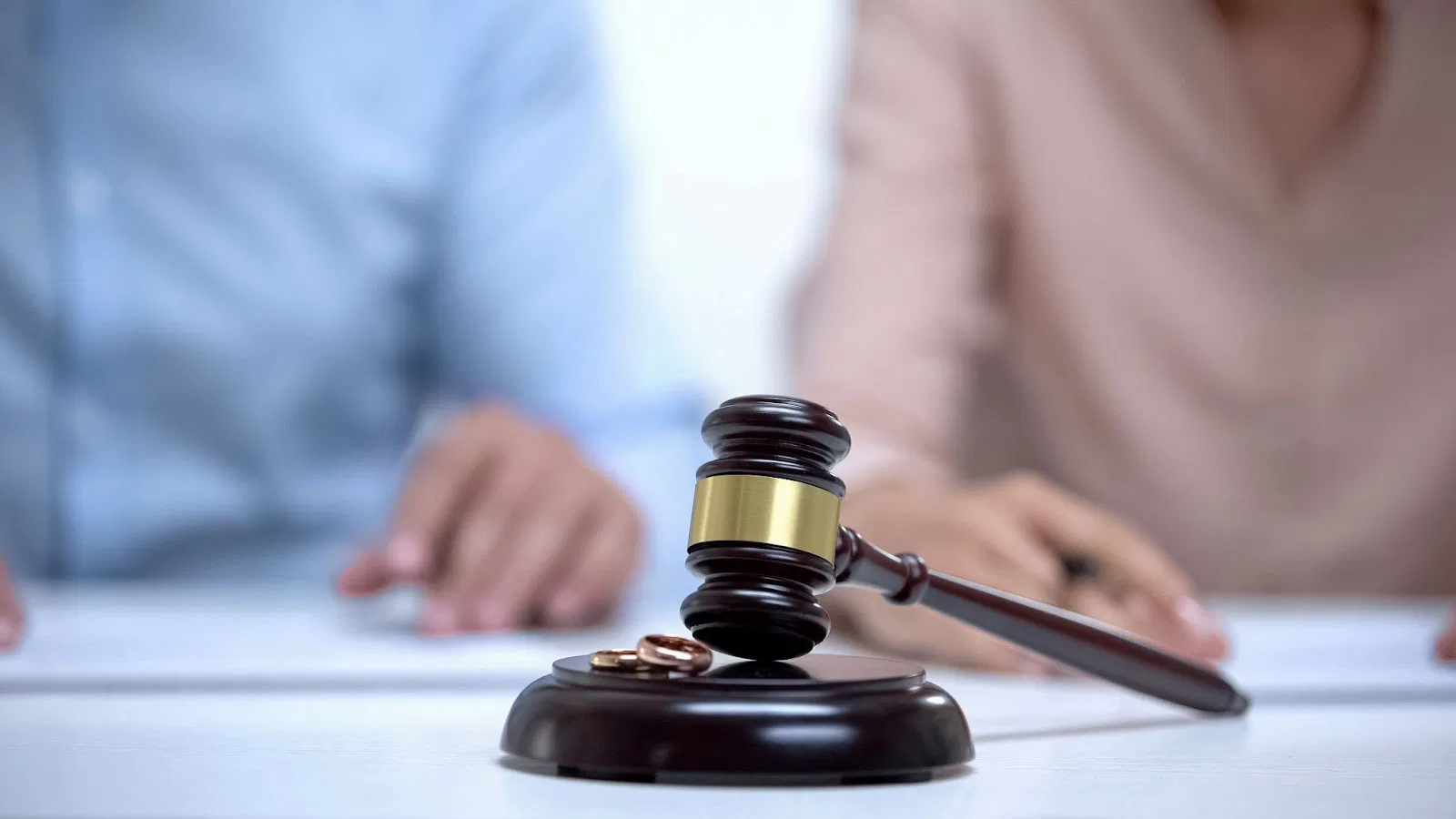 A judge's gavel beside wedding rings on a table, symbolizing divorce consultation in Utah family law.