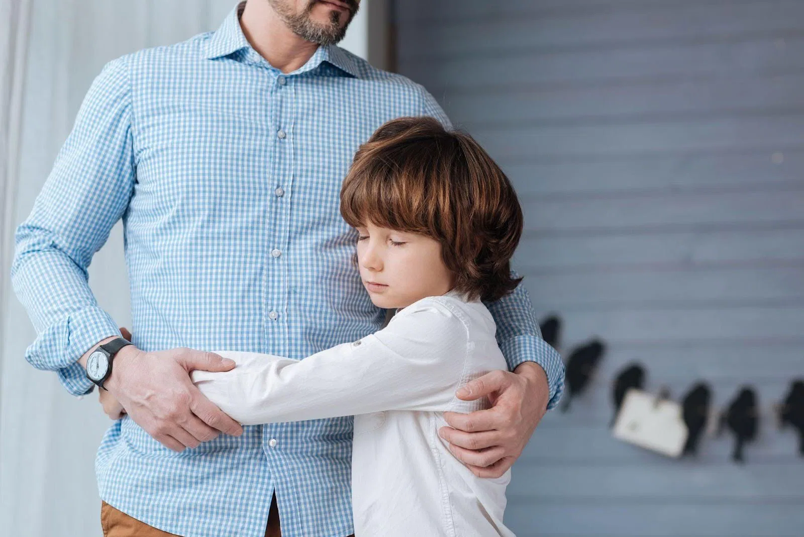 A man and a young boy embrace in a warm hug expressing affection and connection between them